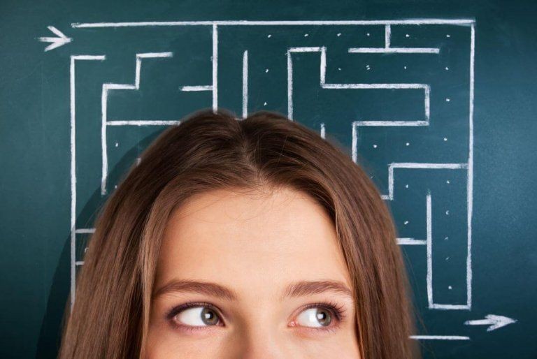 Person looking up at a blackboard maze, symbolizing problem-solving and decision-making.